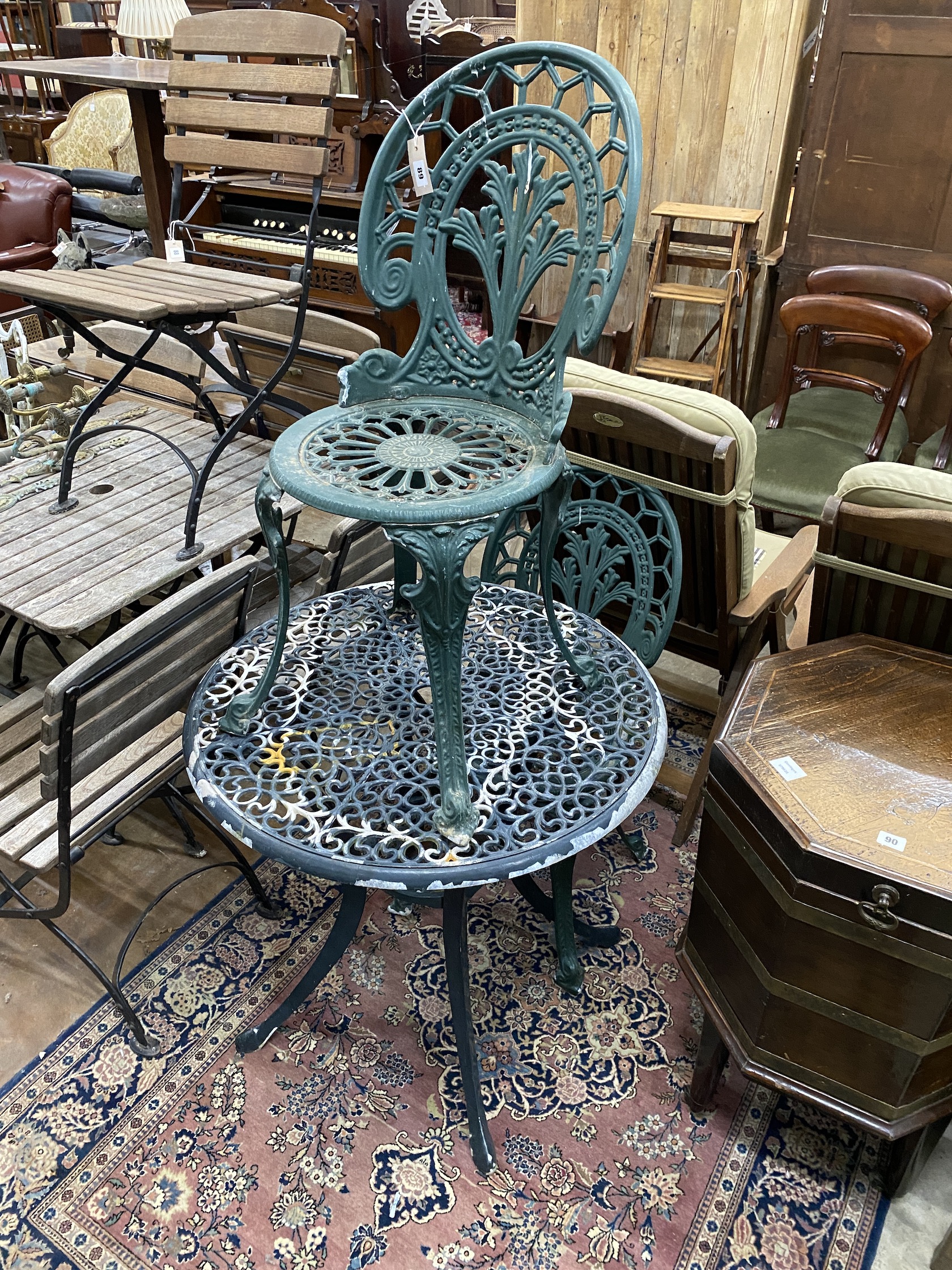A circular painted aluminium garden table, diameter 74cm, height 7cm, together with a pair of garden chairs